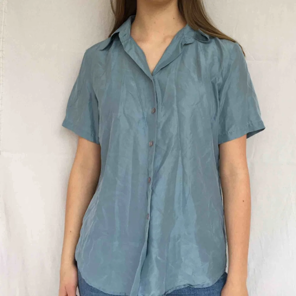 Blå skjorta i 100% siden (därav att den ser lite skrynklig ut), väldigt skön att ha på! Kunden står för frakt på 20kr<3. Skjortor.