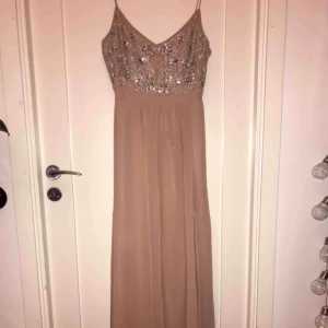  - Jättefin balklänning i smutsrosa med pärlor och paljetter. Lång men öppning vid benet. Använd endast en gång, köpt på Nelly i storlek 38. Kontakta om du är intresserad av denna fina balklänningen!
