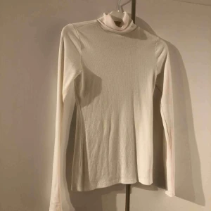  - En vit polotröja. Storlek xs men passar s