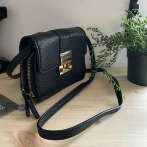  - Liten svart väska med guldiga detaljer. Knappt använd.   Swish betalning. Upphämtning i Sthlm alt köparen betalar frakt (står ej för postens f-ups)  