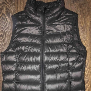  - En svart dunväst köpt från Cubus för snart två år sen, sitter bra och tajt. Använd bara några gånger men är i bra skick!