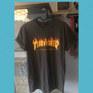  - Thrasher T-shirt med små fläckar som syns på bild 2. Bortklipp lapp men skulle säga storlek M
