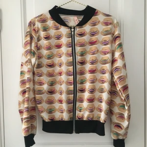  - Tunn jacka med hattar på och svart rib vid hals, ärmslut och längst ned på jackan. Fungerande dragkedja. Köparen betalar frakt!