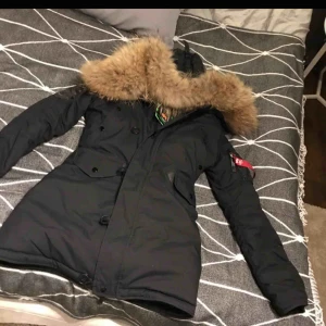  - Väldigt varm vinterjacka med äkta päls  Alpha industries prislappar kvar!        Jackan har hängt mot ett varmt element därav har en lapp inuti smält, synes dock inte alls jackan är i fint skick!