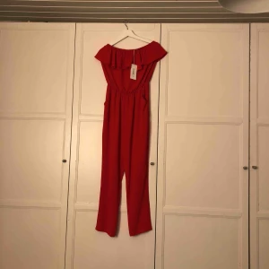  - Röd off-shoulder jumpsuit. Oanvänd, nypris 299 kr. Storlek large, men är liten i storleken, som en small. Köparen står för frakt!!