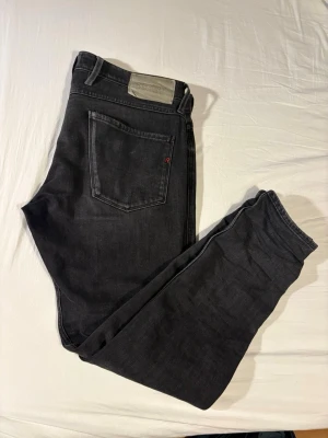 Svarta Replay jeans med rak passform - Säljer ett par svarta jeans från Replay med klassisk rak passform. Jeansen har fem fickor, Replay-logga på bakfickan och en snygg läderpatch i midjan. Tillverkade i slitstarkt denimtyg som sitter skönt hela dagen.