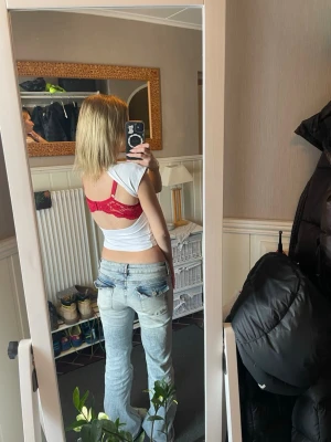 Vit croppad topp med öppen rygg  - Säljer en enkel och stilren vit croppad topp med öppen rygg och korta ärmar. Toppen är figurnära och passar perfekt till jeans eller kjol för en clean look. Materialet känns mjukt och stretchigt, troligen bomull eller en bomullsblandning.