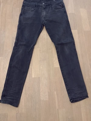 Svarta slim fit jeans - Snygga svarta slim fit jeans med klassisk femficksdesign och knappgylf. Jeansen har en något tvättad look och raka ben. Perfekta för en stilren och avslappnad outfit.