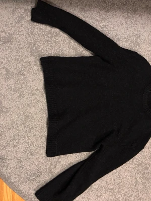 Svart stickad tröja Gina Tricot - Klassisk svart stickad tröja från Gina Tricot i premiumkvalitet. Tröjan har rund halsringning, långa ärmar och ribbade muddar vid ärmslut och nederkant. Perfekt basplagg till garderoben och enkel att matcha. Nypris 399