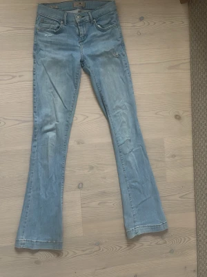 Ljusblå bootcut jeans från LTB - Säljer ett par ljusblå bootcut jeans från LTB med klassisk femficksmodell och snygga slitningar. Jeansen har låg midja och är tillverkade i mjuk denim med lite stretch för extra komfort. Säljer pga för små för mig!