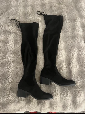 Svarta overknee boots Steve Madden - Säljer ett par svarta overknee boots från Steve Madden med klack och snörning upptill. Boots i mockaimitation som sitter tight längs benet och har en stilren, modern look. Perfekta till höstens outfits. (Pris kan alltid diskuteras)🩷