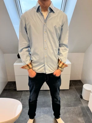 Ljusblå Burberry Skjorta  - Tjena! Nu har vi fått in denna Burberry skjortan i en fet ljusblå färg. Skicket på skjortan är 10/10 vilket som visas på bilderna. Storleken är L men passar M. Pris: endast 899kr men kan sänkas vid snabb och smidig affär💯 // studio II Resell 💙💯