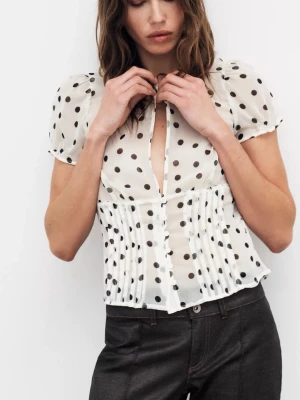 Vit prickig blus med puffärm - Säljer en vit blus med svarta prickar och korta puffärmar (ZARA). Blusen har knäppning framtill och är tillverkad i ett tunt, transparent material som ger en luftig känsla. Den har plisserade detaljer vid midjan och en feminin, figurnära passform. Endast använt en gång. Pris kan diskuteras!💗