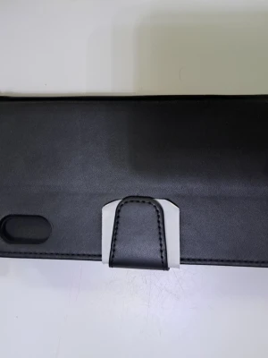 Svart plånboksfodral i läder iPhone XS Max - Snyggt svart plånboksfodral till iPhone XS Max i konstläder med magnetlås och plats för kort. Fodralet har stilrena sömmar och metallknapp för extra detalj. Perfekt för dig som vill skydda mobilen och ha allt samlat på ett ställe. Säljer den för 50 kr