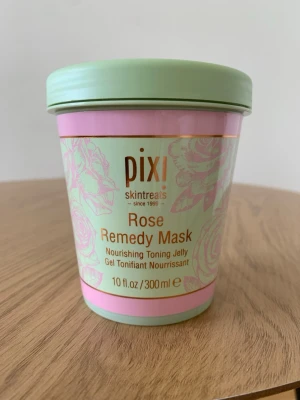 Pixi Rose Remedy Mask 300 ml - Pixi Rose Remedy Mask är en närande tonande gelmask i en mintgrön och rosa burk. Masken innehåller ros och är perfekt för att ge huden extra fukt och lyster. Kommer i en stor förpackning på 300 ml och har en fräsch design med blommönster.