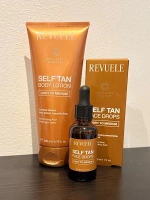 Revuele brun utan sol set - Säljer ett set med Revuele Paradise Bronze Self Tan Body Lotion och Self Tan Face Drops, båda i nyansen Light to Medium. Body lotionen kommer i en kopparfärgad tub och face drops i en brun glasflaska med pipett. Innehåller återfuktande aloe vera och har en fräsch doft. Aldrig använt eller testat 
