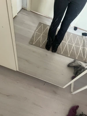 Svarta bootcut jeans - Säljer ett par svarta bootcut jeans med klassisk femficksdesign och hög midja. Jeansen har en snygg passform som sitter tajt över låren och släpper ut vid vaden. Perfekta för dig som gillar en stilren och tidlös look.