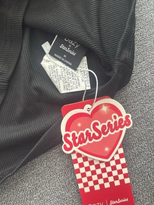 Svart ribbad topp från Dazy x StarSeries - Svart långärmad topp från Dazy x StarSeries med ribbad struktur. Toppen har en rund halsringning och är tillverkad i mjuk polyester, perfekt för en stilren och enkel look. Passar även S