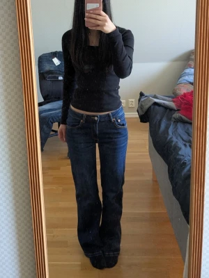 Bootcut jeans från 157, mörkblå - Säljer ett par mörkblå bootcut jeans från 157 med klassisk 90-talsstil. Jeansen har låg midja, utsvängda ben och tydliga kontrastsömmar. Perfekta för dig som gillar retrovibbar och en avslappnad look.