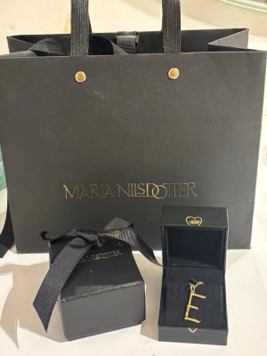 Maria Nilsdotter bokstavshalsband E - Säljer mitt wonky letter necklace med E i längd 45 från Maria Nilsdotter. Äkta guldplaterad halsband i perfekt skick utan några defekter. Kommer i orginalförpackning med två askar och en påse. Pris kan diskuteras