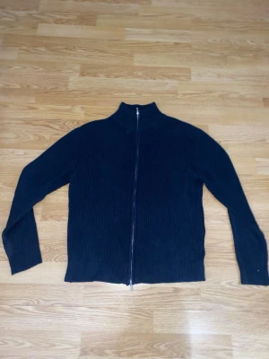 Blå stickad tröja med dragkedja - Möekblå stickad tröja med full-zip dragkedja och krage. Storlek S men passar även M om man vill ha lite mer slim passform.