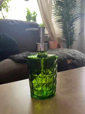 Tvålpump i glas - En grön och silvrig tvålpump i glas. Haft den ett bra tag därav lite slitage på silverfärgen. Vet tyvärr inte var den är ifrån, fick den i present för många år sedan. 