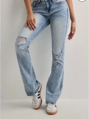 Ljusblå bootcut jeans från True Religion - Ljusblå jeans från true religion med röda sömmar,storlek W27 knappt använda omsydda från midwaist till lowaist det är sytt så att det går att fixa ifall det går upp,nypris 1299!🩷