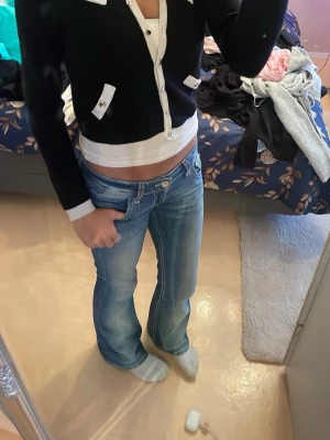 Svart kofta - Svart bomulls kofta med vita och guldfärgade detlajer på framsidan. Passar så bra att ha över ett linne året om. Ger outfiten de lilla extra. Storlek X-XL men passar på mig som är s