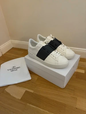 Valentino Garavani open vita marinblå sneakers - Säljer ett par Valentino Garavani Open sneakers. Kommer med originalpåse och box. Pertekta för dig som vill ha en clean men lyxig look. Stl 46/47. 