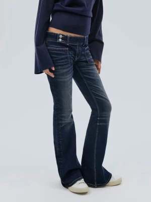 Mörkblå bootcut jeans - Snygga mörkblå bootcut jeans detaljer och markerade sömmar. Jeansen har låg midja, klassisk femficksdesign och stängs med knapp och dragkedja. Perfekta för en avslappnad och trendig look.