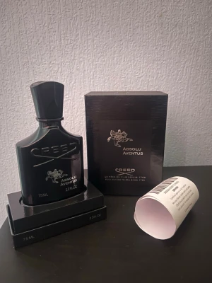 Creed Absolu Aventus parfym 75ml - Lyxig parfym från Creed, modellen Absolu Aventus. Flaskan är svart med elegant design och silverdetaljer. Kommer i originalförpackning med Creed-logga och signatur på locket. Volymen är 75 ml och flaskan har en exklusiv känsla. Parfymen är helt ny. Kvitto inkluderas och skickas samma dag