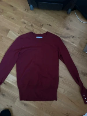 Vinröd stickad tröja Holly & Whyte - Snygg vinröd stickad tröja från Holly & Whyte by Lindex. Tröjan har rund halsringning, långa ärmar och ribbade muddar. Klassisk och enkel design som passar till mycket. Materialet känns mjukt och bekvämt.