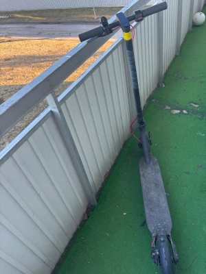 Svart elscooter med ståplatta - Elektrisk scooter i svart med lång ståplatta och styre. Scootern har röda detaljer vid kablarna och en minimalistisk design. Perfekt för att ta sig fram snabbt i stan eller till skolan.