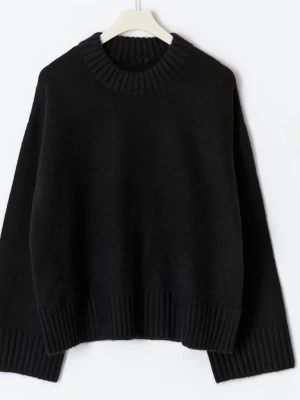 Svart oversized stickad tröja - Mysig svart stickad tröja med oversized passform och bred ribbad kant vid hals, ärmslut och nederkant. Perfekt för lager på lager och enkel att matcha till olika outfits. Tröjan har rund halsringning och långa ärmar.