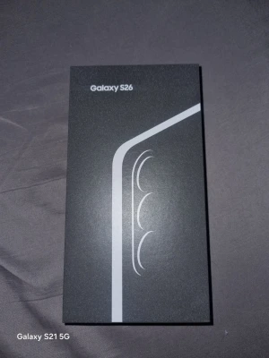 Samsung Galaxy S26 mobiltelefon - Säljer en Samsung Galaxy S26 i originalförpackning. Lådan är svart med stilren design och silverdetaljer. Perfekt för dig som vill ha en modern smartphone med snygg look och avancerade funktioner. Levereras i återvunnen förpackning.