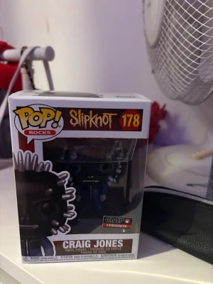 Funko Pop! Slipknot Craig Jones - Säljer en Funko Pop! Rocks figur av Craig Jones från Slipknot, nummer 178. Figuren är i svart och silver med detaljerad mask och EMP Exclusive-märke på förpackningen. Perfekt för samlare av rockprylar och Slipknot-fans. Helt ny och oanvänd!