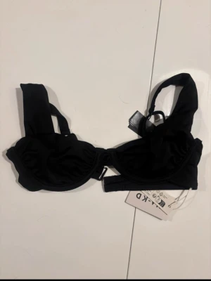 svart bikinitopp nakd - Superfin slutsåld bikiniöverdel som tyvärr blev för liten, endast testad en gång. Reglerbara band, storlek 70b men mer som en 65.