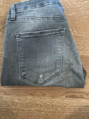 Gråa skinny jeans - Säljer ett par gråa skinny jeans med klassisk femficksdesign. Jeansen har en smal passform och är tillverkade i mjukt denimtyg. Perfekta för en avslappnad och trendig look.