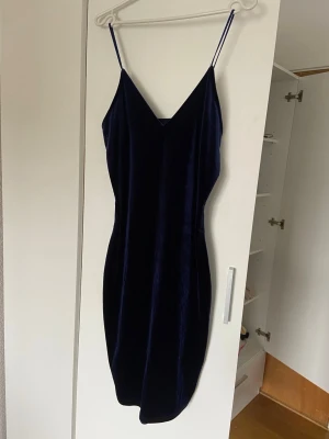 Mörkblå sammetsklänning Bik Bok - Snygg mörkblå sammetsklänning från Bik Bok med smala axelband och v-ringning. Figurnära passform (liten i storlek så passar även dig som använder storlek S) 