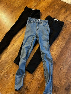Skinny jeans Molly från Gina Tricot - Tre par skinny jeans  2 par från Gina Tricot, modell Molly. 1 par från lager 157 i modellen Snake. Två par är svarta och ett par är klassiskt blå. Jeansen har hög midja, smal passform och stretchigt material som sitter snyggt. Perfekta för en trendig och bekväm look. Alla 3 eller inget