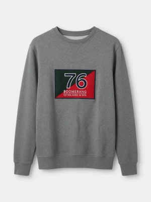 Grå sweatshirt från Boomerang - Grå sweatshirt med stort broderat tryck på bröstet i svart, vitt, rött och grönt med texten '76 Boomerang Established in 1976'. Klassisk rund halsringning och långa ärmar. Perfekt för en avslappnad och stilren look.