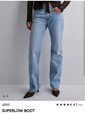 Levi's Superlow Boot ljusblå jeans - Säljer ett par ljusblå Levi's Superlow Boot jeans med låg midja och bootcut passform. Klassisk femficksmodell med Levi's ikoniska bakfickor och patch bak i midjan. Tillverkade i denim med en avslappnad vibe, perfekta till sneakers eller boots.