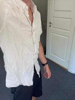 Kortärmad skjorta | sommarskjorta J.Lindeberg - Snygg beige skjorta med korta ärmar och klassisk krage. Skjortan har knäppning framtill med ljusa knappar och är tillverkad i ett lätt bomullstyg. Perfekt för en avslappnad och stilren look.
