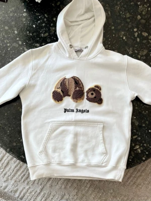 Palm Angels Bear hoodie - Säljer min palm angels hoodie i vitt/brunt.  STORLEK: XL men tröjan har blivit tvättad många gånger —> passar bra på kille 165 cm (eller tjej)   SKICK: skicket är bra men tröjan har några väldigt ljusa fläckar lite här och där som endast går att se om man kolla noggrant. Huvsnöre (drawstring) saknas.