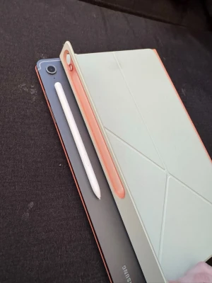 Samsung Galaxy Tab S10 FE plus - S-pen och originalfodral från Samsung medföljer, även ett extra skärmskydd. Sitter ett på också från start. Endast använd i ca 3 veckor  Skyddet är magnetiskt och kan tas isär om man hellre vill ha ett tangentbord istället för den oranga delen. Skyddet har även ett litet veck för där pennan sitter så pennan aldrig åker av. Även den sitter med stark magnet.  Väldigt fint skick, inga repor eller skador. Originallåda finns inkl originalkabel.  Nypris för surfplatta och skydd ligger på ca 11 tusen 