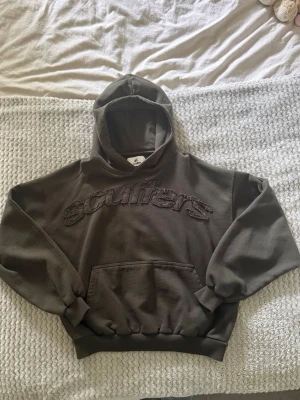 Mörkgrön hoodie från Scuffers - Snygg mörkgrön hoodie från Scuffers med stor broderad logga på bröstet. Hoodien är i färgen raw dark och har endast använts en gång. Storlek S.