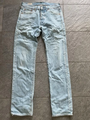 Levi's 501 jeans - Säljer ett par klassiska ljusblå jeans från Levi's med rak passform och fem fickor. Perfekta för en avslappnad och trendig look. Riktigt bra skick och till en billig peng! 