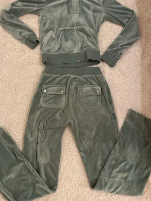 Grönt Juicy Couture set - säljer ett grönt juicy set❤️ är i väldigt bra skick förutom att två st av de silvriga grejerna som hänger på snörena är borta men annars inga fel! hör gärna av dig om du har frågor❤️