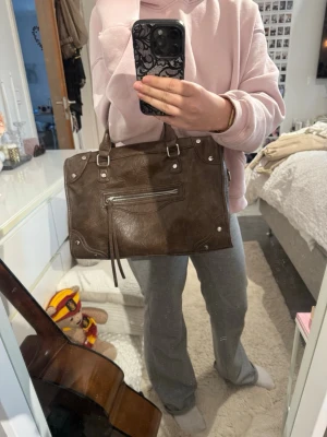 Brun väska - Snygg brun oanvänd handväska från Gina tricot. Den fungerar perfekt som en väska att ha i armvecket men även som en axelväska, så de finns ett axelband inuti väskan!💕