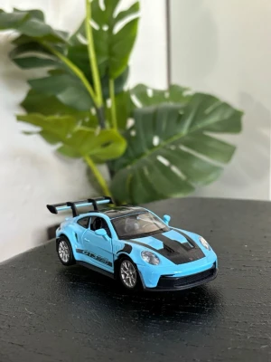 Blå Porsche GT3 RS leksaksbil - Säljer en detaljerad leksaksbil i form av en blå Porsche GT3 RS med svarta detaljer och stor bakvinge. Bilen är tillverkad i metall och plast och har realistiska fälgar samt tydliga dekaler på sidorna. Perfekt för dig som gillar samlarbilar eller vill ha en snygg prydnad.